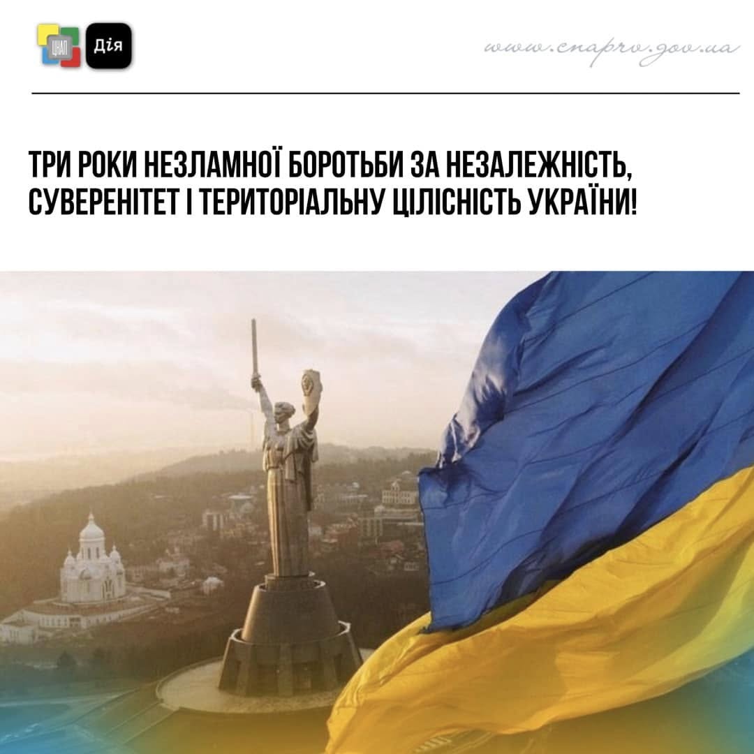 Монумент 'Батьківщина - Мати' на задньому фоні, на передньому фоні майорить жовто-блакитний стяг
